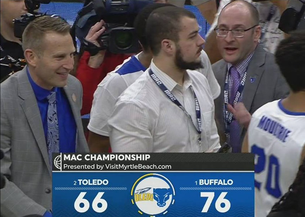 On court amid players and broadcast cameras following a MAC Championship win